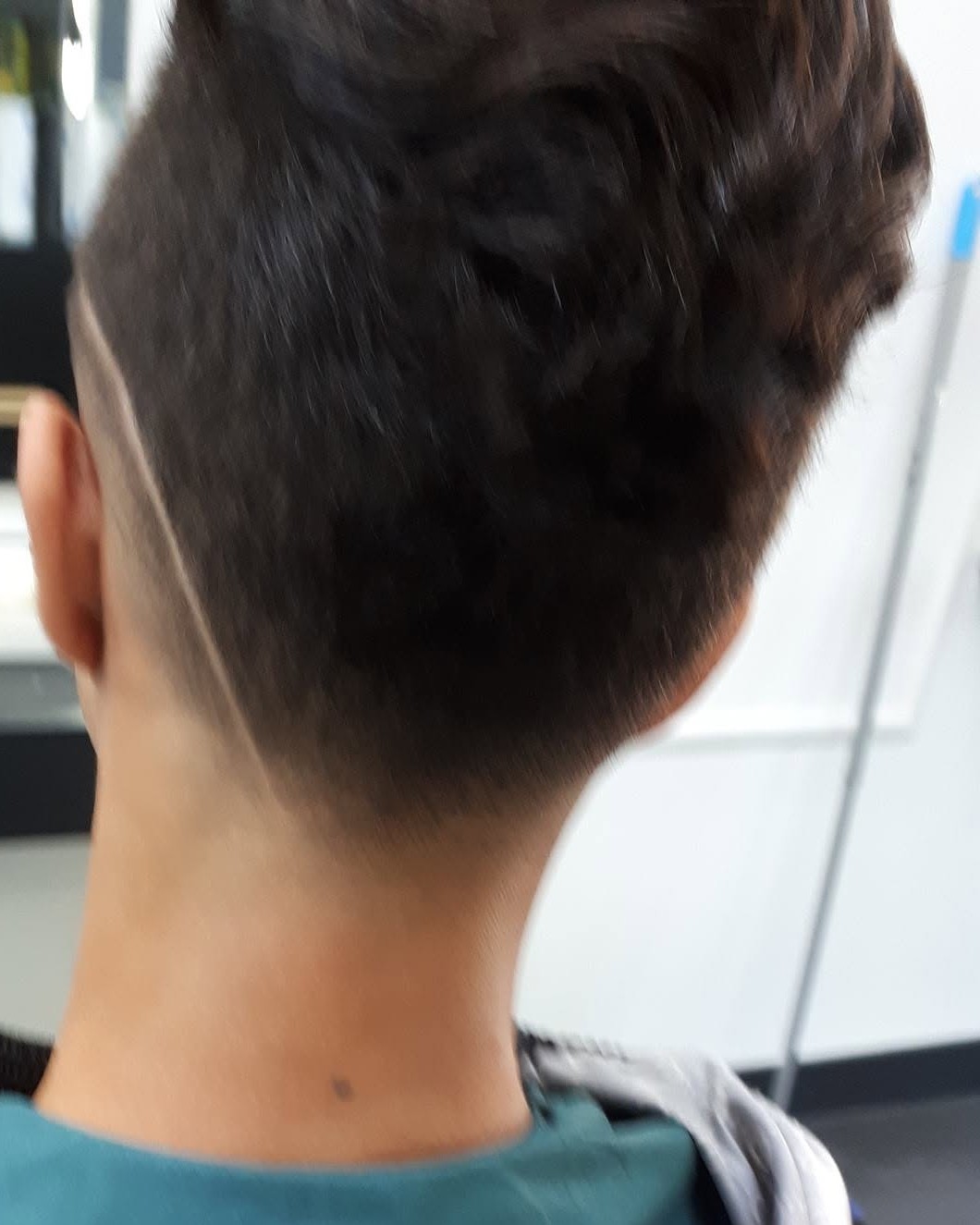 Achterhoofd van een klant met een kort opgeschoren nek en een lijn langs de zijkant